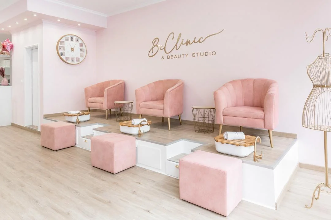 Sala de espera com poltronas rosa e estações de pedicure